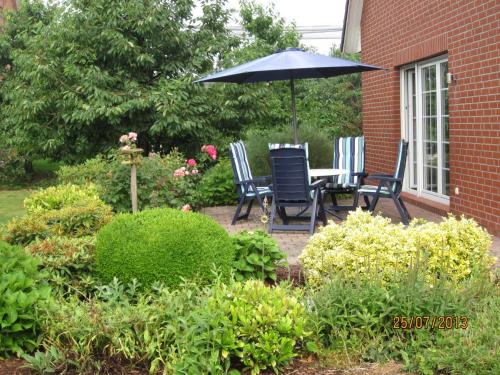 a patio with a table and chairs and an umbrella at Ferienhaus Minners in Jork