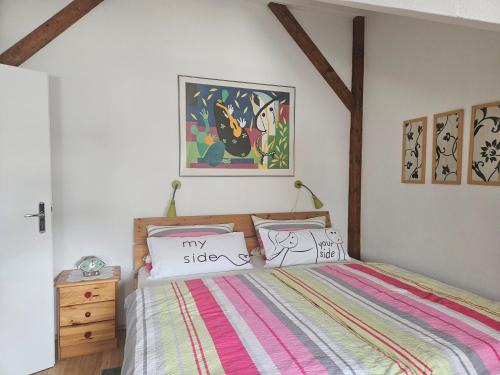 a bedroom with a bed with a colorful striped bedspread at Ferienwohnung Wartturmblick in Nierstein