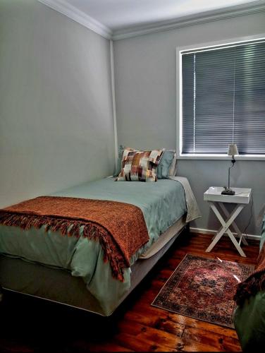 a bedroom with a bed and a window and a rug at Herdman's Rest Farmstay in Lady Grey