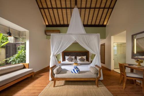 a bedroom with a bed with a canopy at The Lokha Ubud Resort, Villas & SPA in Ubud