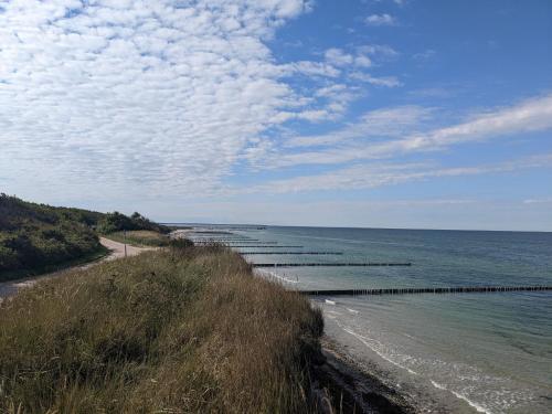 a beach with a long pier in the water at An der Schmiedestraße Strandläufer in Wustrow