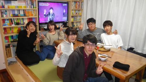 un grupo de personas sentadas alrededor de una mesa dando pulgares hacia arriba en B&B Nagomi en Tokio