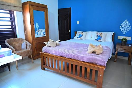 a bedroom with a large bed with purple sheets at Kannur Beach view Homestay in Kannur