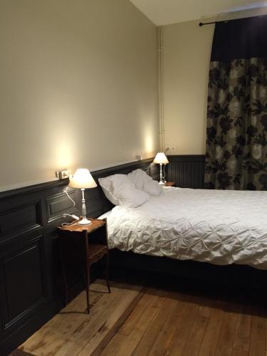 - une chambre avec un lit et deux lampes sur les tables dans l'établissement La Petite Cour - Périgueux, à Périgueux