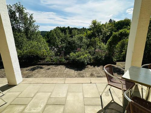 a patio with two chairs and a view of a garden at GER-Haus in Waischenfeld