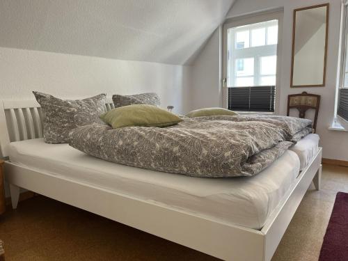 a bed with a blanket and pillows on it at Ferienwohnung am Kirchplatz 25561 in Weener