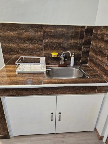 a kitchen with white cabinets and a sink at Raed Homestay by ASH in Biñan