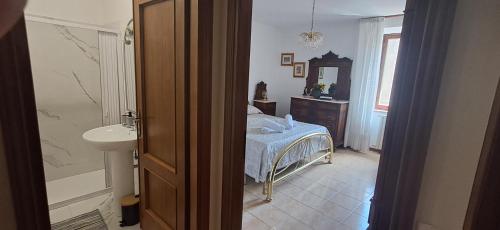 ein Badezimmer mit Bett, Waschbecken und Spiegel in der Unterkunft Locanda Rum e Pera in Acquapendente