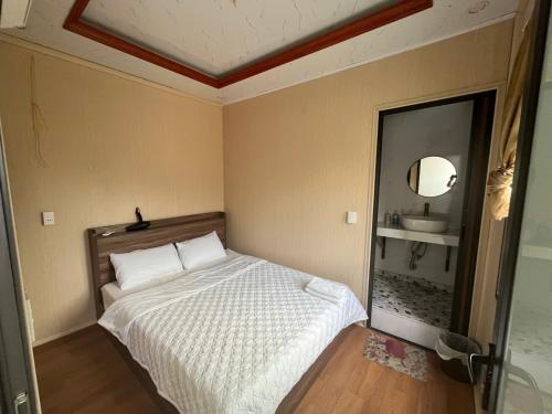 a small bedroom with a bed and a mirror at Thanh Thao Hostel - HaGiang Loop Tour in Làng Lap