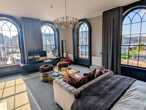 salon z łóżkiem, kanapą i oknami w obiekcie One Capel Suites w Dublinie