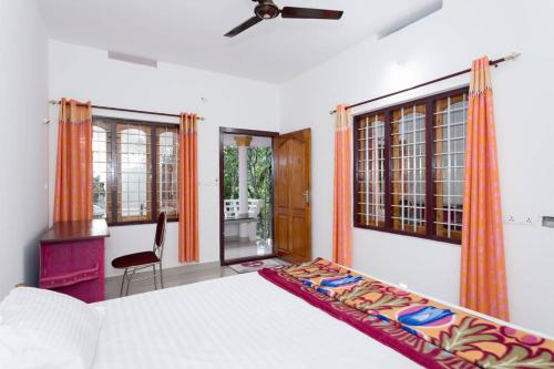 ein Schlafzimmer mit einem Bett und einem Stuhl und Fenstern in der Unterkunft Mount Spring Valley Homestay in Thekkady