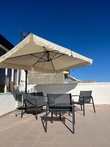 a patio with two chairs and a large umbrella at Casa Manzoni- Appartamento con terrazzo in centro in Mussomeli