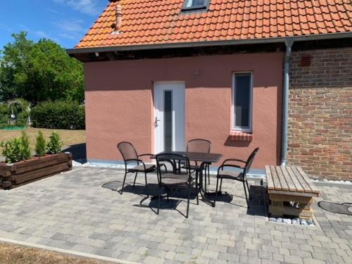a patio with a table and chairs in front of a house at Ferienwohnungen Schaprode Udars in Udars
