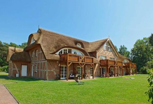 a large large house with a thatched roof at Haus an der Düne Whg 10 in Lobbe