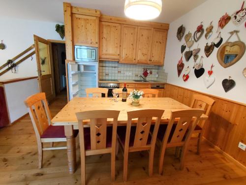 a kitchen with a wooden dining table and chairs at Appartements Bel Monte - Kärnten Card im Sommer inklusive in Bad Kleinkirchheim