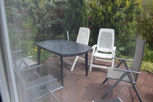 a table and four chairs on a patio at Ferienwohnung am Kittenbach in Utting am Ammersee