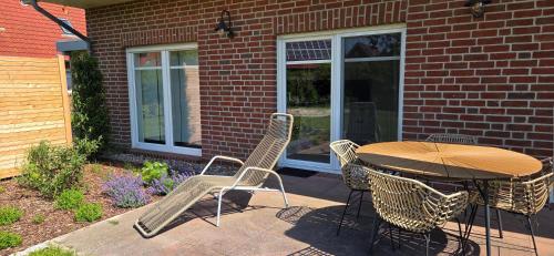 a patio with a table and chairs in front of a building at Nr 200 - Ferienwohnung Süderriff in Neuharlingersiel