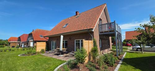 a house with a balcony on the front of it at Nr 200 - Ferienwohnung Süderriff in Neuharlingersiel