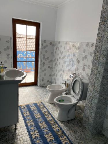 a bathroom with two toilets and a sink and a window at Casa cu flori in Tulcea