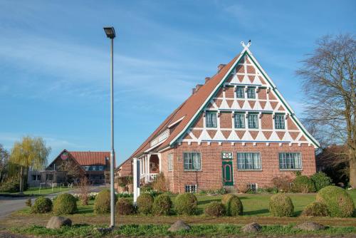 ein großes Backsteingebäude mit dreieckigem Dach in der Unterkunft Altländer Obsthof in Hollern-Twielenfleth