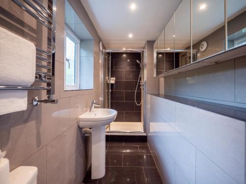 a bathroom with a sink and a toilet and a shower at Stylish Reverse-Level Retreat for couples in Totnes