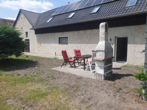 two red chairs and a table in front of a house at Ferienwohnungen Nochten in Nochten