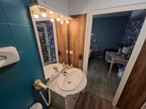a bathroom with a sink and a mirror at Les Cols Verts - Logis Hôtels in La Tranche-sur-Mer