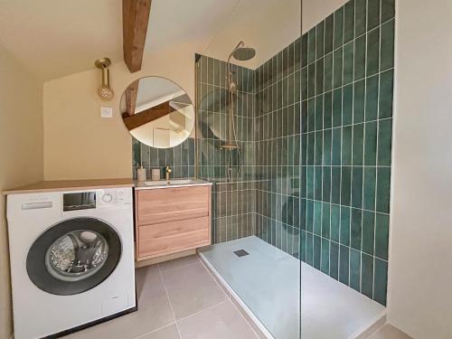 a bathroom with a washing machine and a mirror at Élégant T3 moderne et central, parking inclus in Montargis