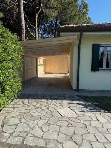 a building with a garage and a stone driveway at Adria in Isola Albarella