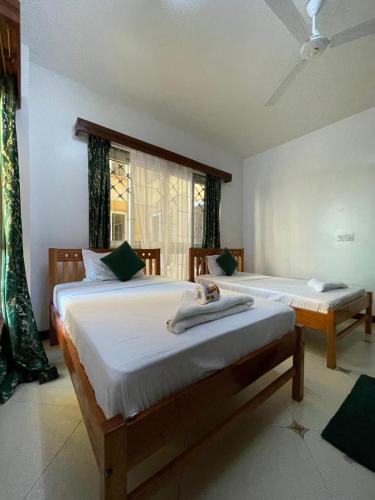 a bedroom with two beds and a window at Ocean Cliff Homes 4 bedroom shared apartment in Mombasa