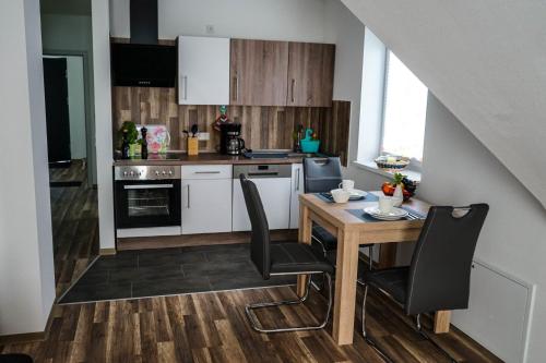 a small kitchen with a wooden table and chairs at Ferienhaus Voss in Alt Zauche