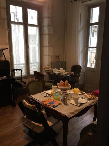 un tavolo con cibo sopra in una stanza con finestre di La Petite Cour - Périgueux a Périgueux