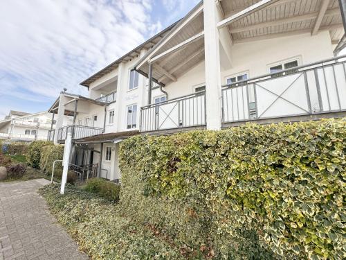 a white building with a hedge in front of it at Villa Linde Whg 23 mit Terrasse in Göhren