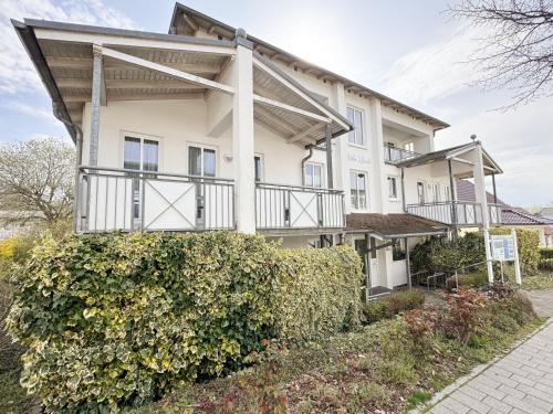 a large white house with a balcony at Villa Linde Whg 23 mit Terrasse in Göhren