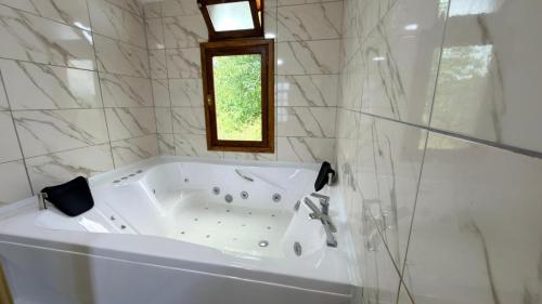 a white tub in a bathroom with a window at Yücebaş Konağı in Fatsa