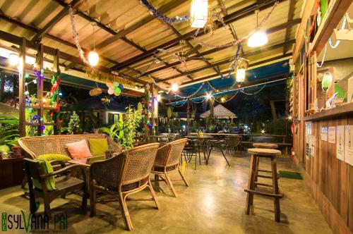 a restaurant with tables and chairs and lights at The Sylvana Pai in Pai