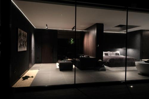 a dark room with a bed and a bathroom at The Ruler Bali in Penginyahan