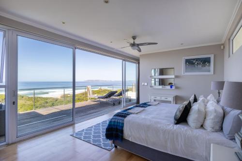 a bedroom with a bed and a view of the ocean at Seascape in Plettenberg Bay