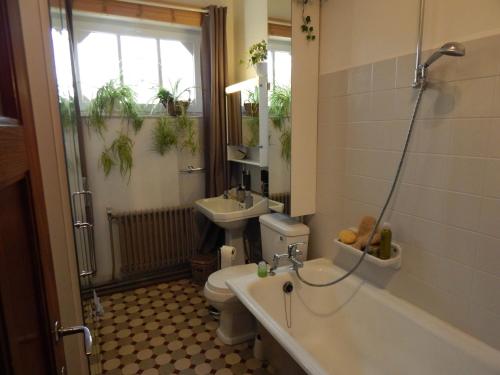 a bathroom with a tub and a toilet and a sink at Les Remparts in Binche
