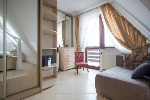 ein Schlafzimmer mit einem Bett, einer Kommode und einem Fenster in der Unterkunft ZAKOpanorama in Zakopane
