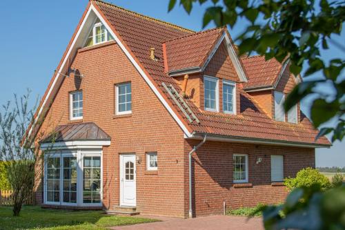 a red brick house with a white door at Ferienhaus Robby in Stedesdorf