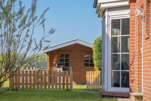 a wooden cabin with a fence in the yard at Ferienhaus Robby in Stedesdorf