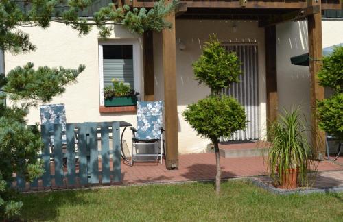 a patio with two chairs and a table in a yard at Neue moderne Ferienwohnung, separater Eingang, Seenähe in Möllen