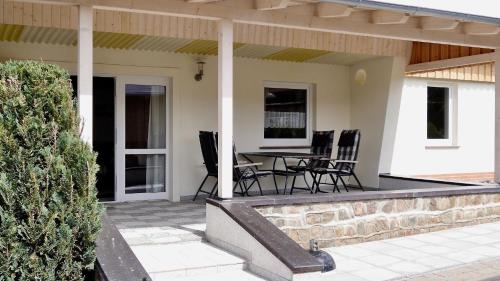 a patio with a table and chairs on it at Bungalow am See in Basedow