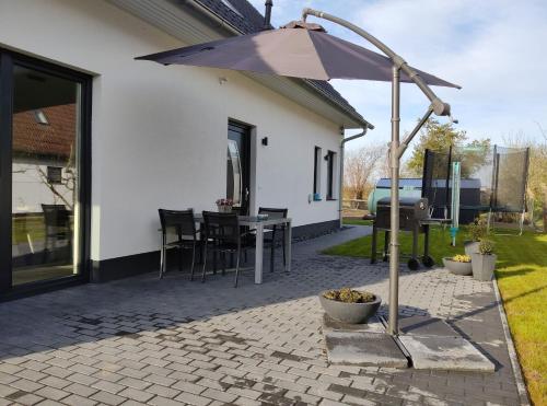 a patio with an umbrella in front of a house at Rügen Fewo 301 in Haidhof