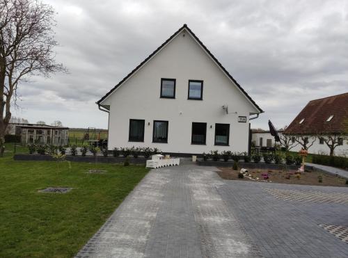 a white house with black windows and a driveway at Rügen Fewo 301 in Haidhof