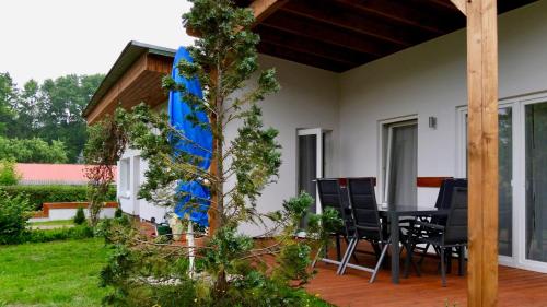 a house with a table and chairs on a patio at Bungalow Wallner in Basedow