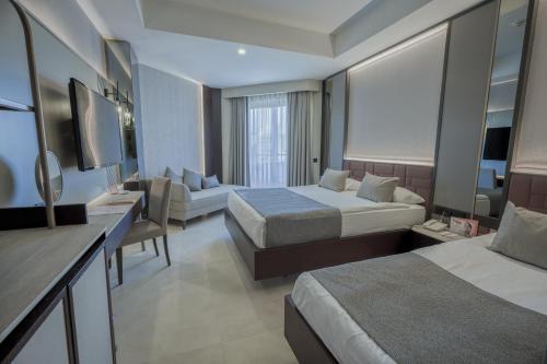 a hotel room with two beds and a couch at Orange Palace Side - All Inclusive in Side