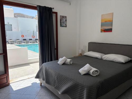 a bedroom with a bed with towels on it at Tarelis Beach Apartments & Studios in Kamari