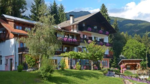a building with flowers on the balconies of it at Frühstückspension Lemberger in Dellach im Drautal